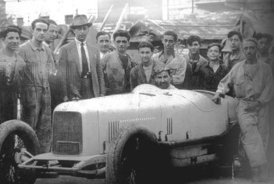 The Maserati brothers with employees and one of their sport cars in 1930